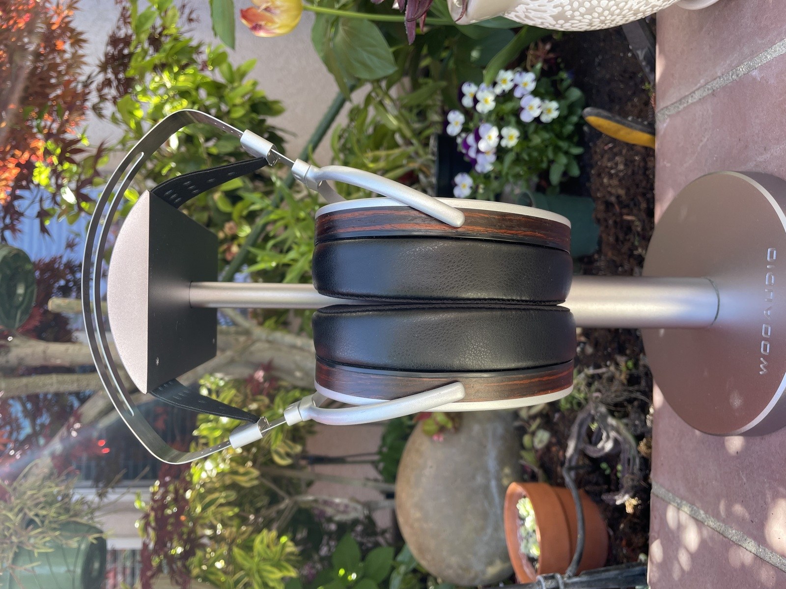 HIFIMAN HE1000se on a Woo Audio headphone stand next to a garden with pink flowers